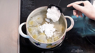 キッチンペーパーの上から残りの砂糖の半量を加え、5分煮ているところ