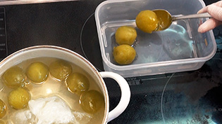 消毒済みの保存容器に梅を移しているところ