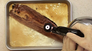 蒲焼に熱湯をかけてたれを取り除く
