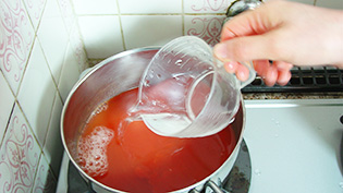 鍋にトマトジュースと水を入れて火にかけている