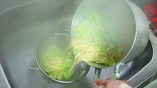 スパゲティをキャベツやしめじごとザルに上げて、水気を切っている