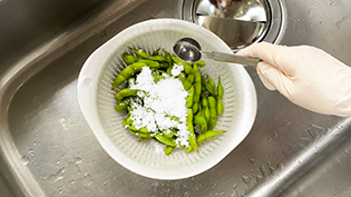 八尾枝豆のゆがき方:枝豆をザルに入れて、大さじ3杯の塩をふる