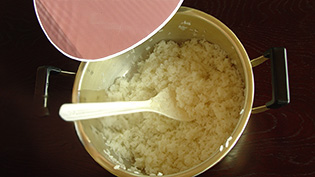 すし飯を、うちわであおいで急速に冷ましている